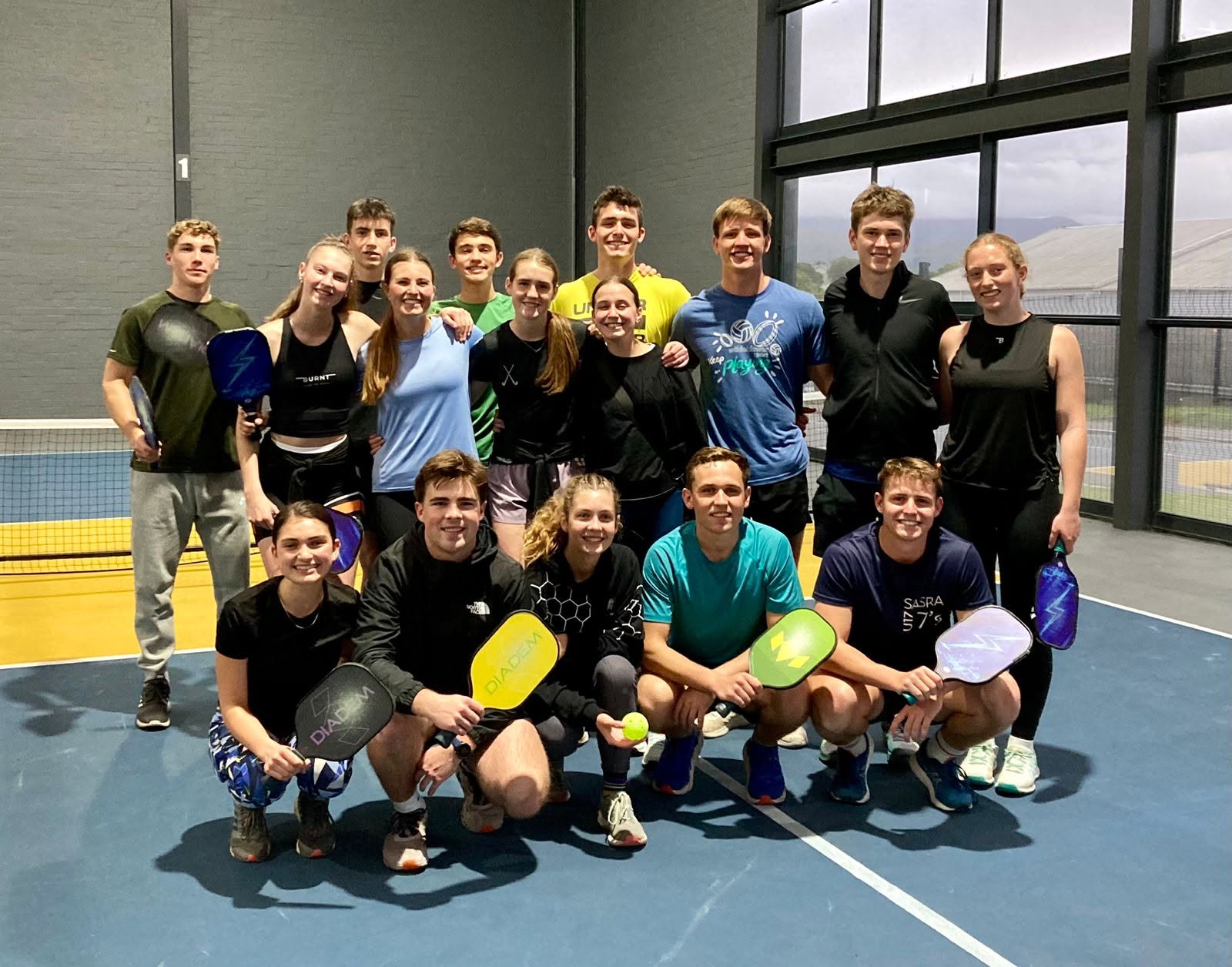 A group of players together on an indoor pickleball court